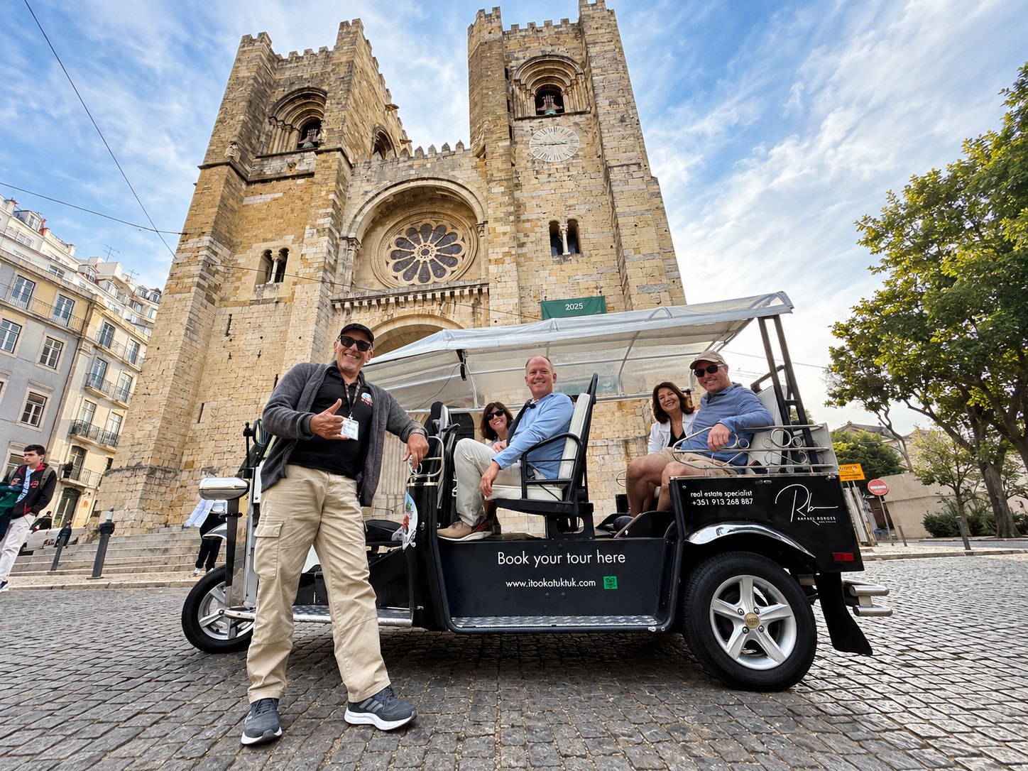 A guide and guests in a tuk tuk in front of Lisbon Cathedral