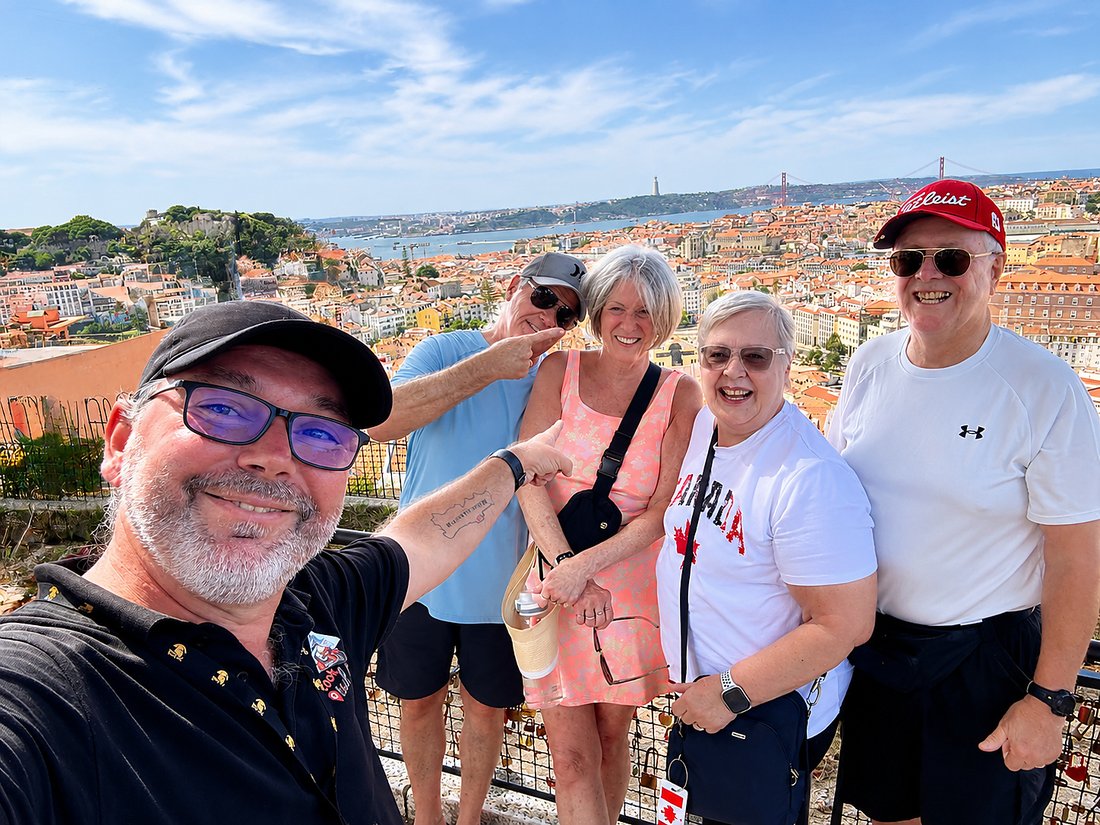 A guide and guests at a Lisbon viewpoint above the city rooftops