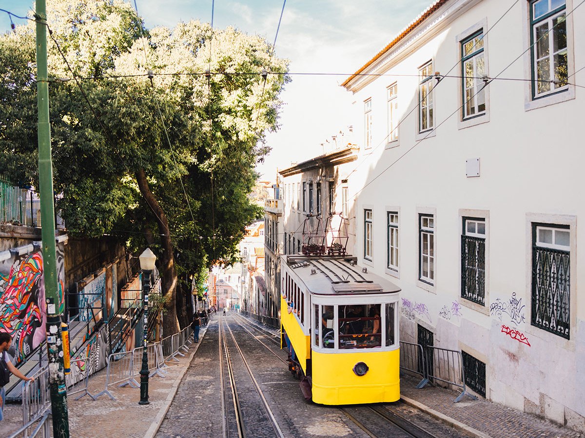 A yellow funicular on a steep street climbing towards Bairro Alto