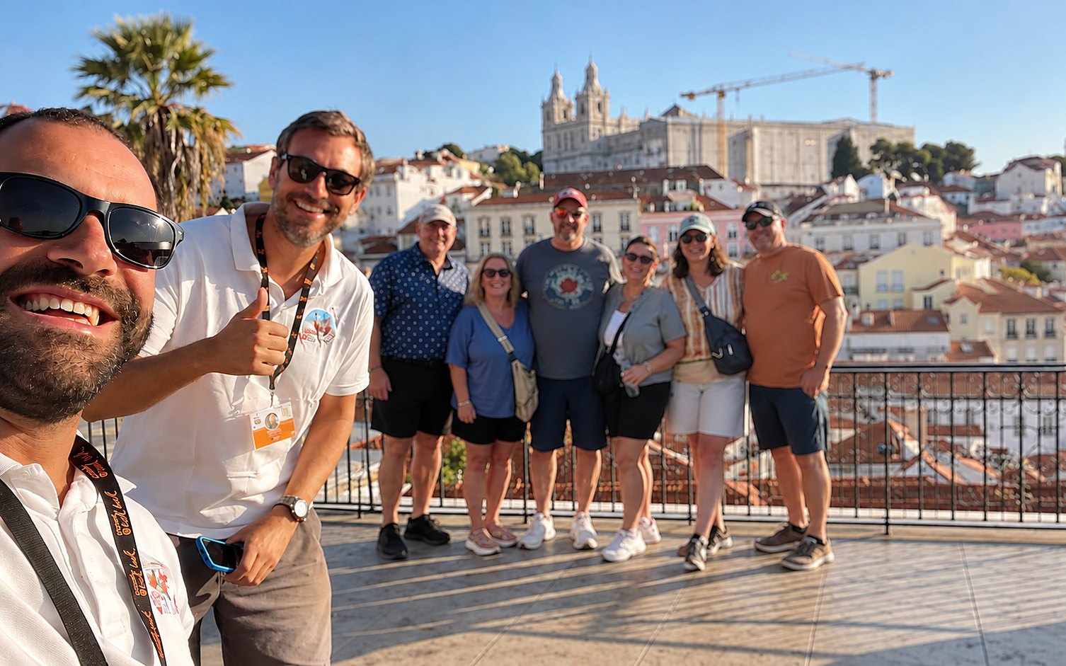 Two I Took a Tuk Tuk guides taking a selfie with their guests at a Lisbon viewpoint
